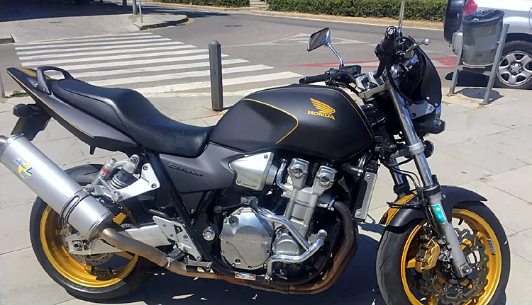 Moto Honda negra con llantas doradas tras pasar por el taller