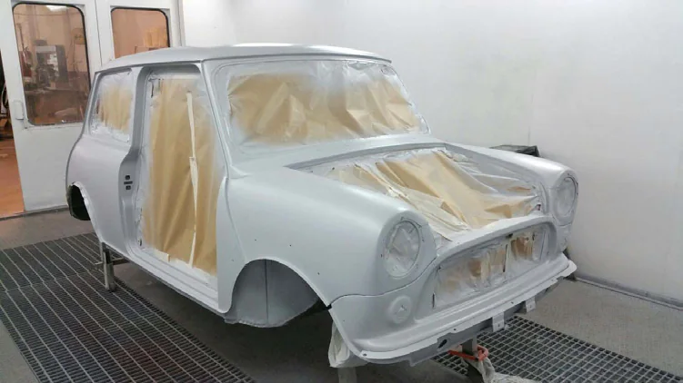 Mini clásico en aparejo gris y enmascarado en la cabina de pintura