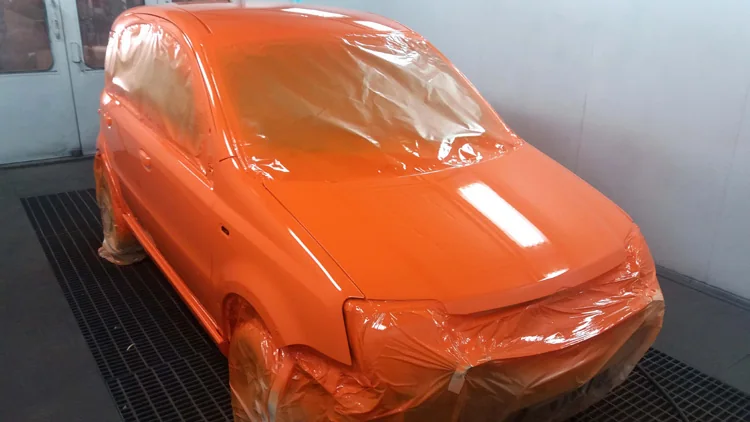 Coche pintado en naranja dentro de la cabina