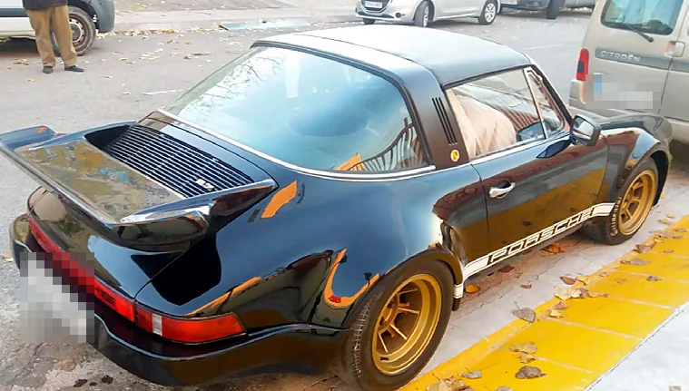 Porsche 911 negro con llantas doradas tras pasar por el taller